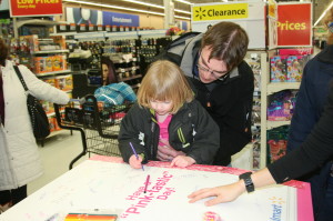 Walmart stores throughout Canada were hosting a month-long celebration in honour of Barbie's birthday. Many local girls were out for the celebration at the Walmart in Bolton. Ellie Heath, 3, from Bolton needed some help from her father Julian as she signed the birthday card for Barbie. The fashion-icon doll officially turned 54 March 9. Photo by Bill Rea