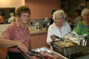 HAM SUPPER AT SANDHILL CHURCH There were a lot of hungry diners out recently at Sandhill United Church. The occasion was the annual Ham Supper, and a lot of work went into getting everything ready. Edna Wright and Marjorie Slack were among those getting things set up for the serving. Photo by Bill Rea 