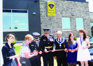 Inspector Rose DiMarco was assisted by Mayor Marolyn Morrison, OPP Commissioner Chris Lewis and Peel Region Chair and CEO Emil Kolb in cutting the ribbon Tuesday to officially open the new Caledon OPP station on Innis Lake Road in Caledon East. Holding the ribbon were Robert F. Hall Catholic Secondary School students Nicole Rak, Christine Skowron and Alexandra Scandolo, who along with Brigida DiMatteo, created a mural which will be on permanent display in the front hall fo the station. Photo by Bill Rea 