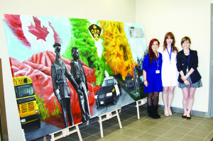 Robert F. Hall Catholic Secondary School students Christine Skowron, Alexandra Scandolo and Nicole Rak are seen here with this mural they created, along with Brigida DiMatteo, in the front hall of the new OPP station. Photo by Bill Rea