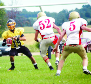 TNT Express quarterback Andrew Tee looks for a receiver while Cambridge Lions defenders surround him during Sunday's Ontario Minor Football League semifinals in Beeton. The Express earned the right to advance to the championship this Sunday after leaving the field with a 65-6 win over Cambridge.