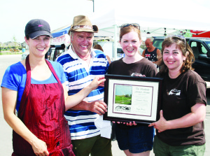 TOWN RECOGNIZES NEW FARMERS' MARKET SouthFields Village Farmers Market has been operating Thursday afternoons for a couple of weeks, and the new presence in the community received recognition recently from the Town of Caledon. Councillor Gord McClure was on hand, representing Mayor Marolyn Morrison, in presenting this plaque to the organizers. On hand to accept were Melissa Downey of Downey's Farm Market, steering committee member Kelley Joyce and market manager Yevgenia Casale. Photo by Bill Rea