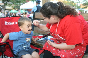 The staff at the John H. Glenn State Farm office were represented at the Madness offering face painting. Patrizia Eltalawy was working on a creation for Owen Beasley, 4, of Bolton.