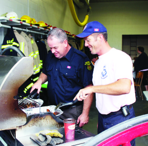 FIREFIGHTERS FEED THE CROWDS Members of the Alton Fire hall hosted a pancake breakfast last Saturday, as part of the observations for Fire Prevention Week. Firefighters Dan Forbes and Bryan Whyton were hard at work with the cooking chores. Photo by Bill Rea