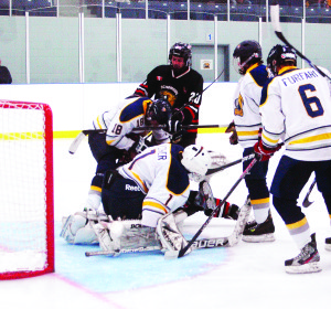 Caledon Golden Hawks goalie Eric Pitcher pounces on the puck as players swarm the net during the third period of Sunday night's home game against the Schomberg Cougars. The Hawks won this game 5-3 to go into first place in the GMOHL standings after a six-point weekend. Photo by Brian Lockhart