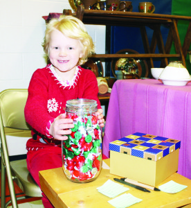 KISSES FOR TYPHOON RELIEF There have been a number of efforts started around the world to assist people in the Philippines impacted by the recent Typhoon Haiyan, and Evelyn Hesjedahl, a Grade 2 student at Caledon East Public School was doing her bit Saturday as part of the annual Christmas Craft Show at the school. She put a collection of candy kisses in this jar, and invited people to guess how many there were. The effort raised $40, which will be sent to the Red Cross so it can be matched by the government. “I wanted to raise money so they can survive,” she said. “This is what I came up with. I wanted to do it with candies because I like candies.” There were 317 kisses in the jar. Photo by Bill Rea