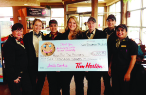 Maggie Patten, manager of special events at Reach for the Rainbow, was flanked by Tim Horton employees as she accepted the $6,000 contribution.