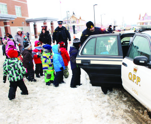 Caledon OPP Constable Greg Page was holding the door as students from SouthFields Village Public School were loading up their contributions to the annual Cram the Cruiser program. The contributions went to the Orangeville Food Bank. Photo by Bill Rea