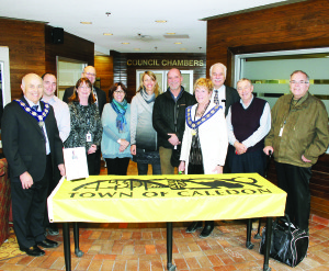 This Caledon flag, bearing messages of good luck, will be going to snowboard cross Olympian Jake Holden. On hand for the signing last Thursday were Peel Region Chair Emil Kolb, Councillors Rob Mezzapelli, Patti Foley and Allan Thompson, Holden's aunt Lorrie Holden and his parents Renee and Waldo, Mayor Marolyn Morrison and Councillors Richard Paterak, Doug Beffort and Richard Whitehead. Photo by Bill Rea