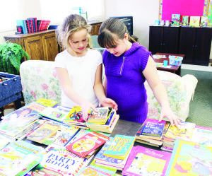SALE AT CAVEN CHURCH There were lots of bargains available recently as Caven Presbyterian Church in Bolton hosted a Book and Bake Sale. Nicole Gilchrist, 9, and Hailey Goodfellow, 10, were busy browsing through the inventory. Photo by Bill Rea