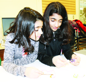 LEARNING ABOUT ROBOTS Robots can be artists too, and youngsters learned about that last Thursday in a March break program held at the Albion-Bolton branch of Caledon Public Library. Neela Jalilian, 8, of Cheltenham and her sister Tia, 10, were busy assembling their creation. Photo by Bill Rea