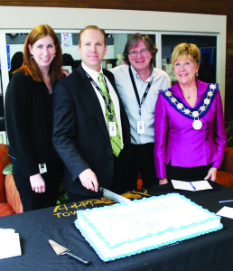 Parks and Recreation Director Kristene Scott, Manager of Parks and Landscape Architect Brian Baird and Mayor Marolyn Morrison flanked Marc Seguin as he cut this ceremonial cake at least week's going-away event. Photo by Bill Rea