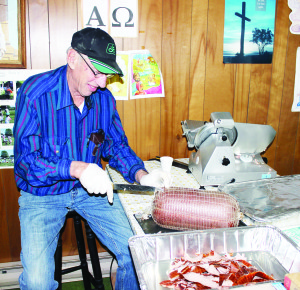 HAM SUPPER AT SANDHILL There were plenty of hungry people out recently for the annual Ham Supper at Sandhill United Church. Needless to say, there was lots of ham available, and Roy Wright is seen here hard at work carving it. Photo by Bill Rea