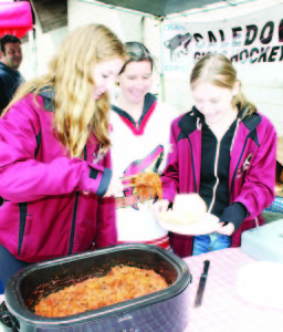Members of Caledon Coyotes Girls' Hockey Club were helping provide the food at the show Saturday. Executive member Helen Wilks was flanked by players Jennifer Cowan and Alexis Wilks serving up Polled Pork.