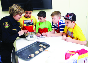 Last week was Police Week, and Caledon OPP officers found lots of things to do to increase their presence in the community, and that included working with local students in making cookies at The Exchange in Bolton. Constable Brenda Evans was working with James Bolton Public School students Connor Cumming, Sam Hoffman, Cameron Stewart and Michael Nobrega at the counter. Photo by Bill Rea