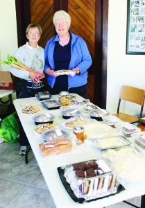YARD AND GARAGE SALE AT CHURCH There were lots of bargains to be had recently at the annual Yard and Garage Sale at Trinity Anglican Church in Campbell's Cross. Kathy Mauer and Nancy Ferguson were helping to run things at the baked goods table. Photo by Bill Rea