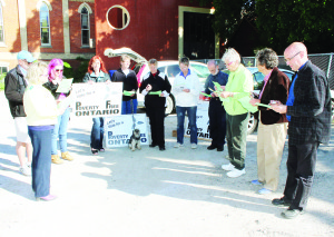 VIGIL HELD AGAINST POVERTY With the provincial election approaching, the Parish of Christ Church in Bolton held a vigil last Thursday evening in the parking lot of Bolton United Church, calling on participants to vote for a poverty-free Ontario. Dufferin-Caledon Green Party candidate Karren Wallace (far left) was among those taking part. Photo by Bill Rea