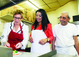 Domenic Caruso of Caruso Gourmet Pizza was watching while Premier Kathleen Wynne and Liberal candidate Bobbie Daid tried their hand at pizza making. Photo by Bill Rea