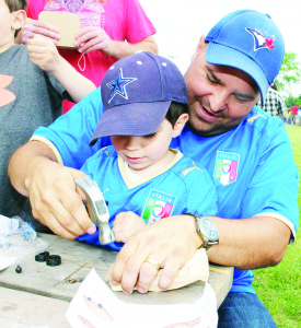 Alex Petricca of Caledon East was helping his son Nathan, 3, handle the hammer as they worked together assembling this car at the Home Depot station.