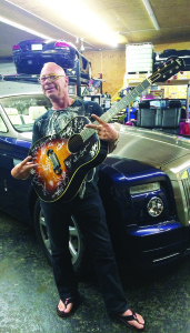 Tim Schmidt shows off a one-of-a-kind autographed guitar, up for grabs in an auction.