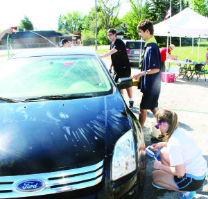 RAISING MONEY FOR CAMP Members of the 1st Bolton Venturers were out recenlty continuing their efforts to raise money to attend the national Jamboree in Newfoundland this month. They were out washing cars. Seen here hard at work are William Newell, Max Gunter and Alexandra White. Photo by Bill Rea