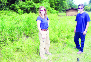 Lisa Erdle and Connor Johnston stand near some waist-high grass they had to deal with.