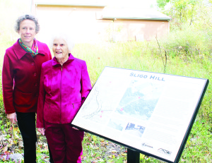 Caledon's Heritage Resource Officer Sally Drummond and local resident Helen Hamilton were standing by the sign marking the history of Sligo Hill. Photo by Bill Rea