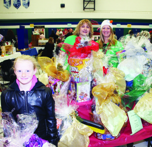 The halls and rooms were packed recently for the 23rd annual Craft and Gift Show, put on by the Caledon East Community School Association. Classes at the school contributed to the creation of these gift baskets, which were raffled off. Elise Noack, 9, is seen here with parent volunteers Sandra Peche and Tina Noack.