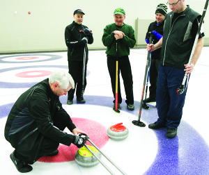 Jack Purves measures the final rock thrown by Skip Scott Boynton in last weeks' men's league action. The point per end game resulted in a 5mm difference after the measurement went to Team Boynton for a 6-6 tie. Photo by Shellee Morning