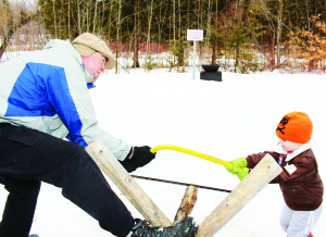 People taking in the Sugarbush festival got to practise some of the chores that were routine many years ago Donald Robertson of Brampton and his grandson Chase Vilone-Wilson, 4, made short work sawing this tree Saturday.