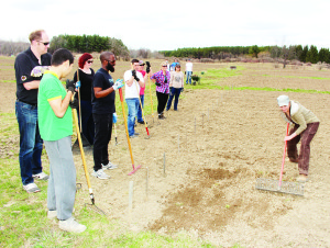 Farm Manager Shannon Lee was demonstrating the proper raking technique to the volunteers.