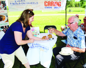 Caledon Meals on Wheels had some light refreshments to offer at the Seniors' Rest Stop they were running. Meals on Wheels Executive Director Christine Sevigny was offering some cookies to Bob Wiggins of Bolton.