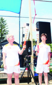 Inglewood resident Stacey Arthur accepted the Pan Am Flame from Ethan Mumford, 13, of Bolton, as part of the Inglewood Day observances “It's a once-in-a-lifetime opportunity,” Ethan said.