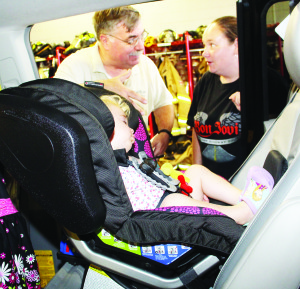 CHILD CAR SEAT CLINIC Caledon OPP Auxiliary officers recently held the latest of their child car seat clinics. Aux. Sergeant Jim Drake was showing Katherine Laffin how to adjust the seat that contained Abigail Laffin, 2. 