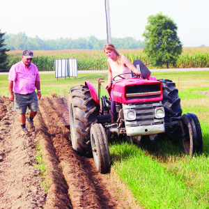 Natalie Vink of Wrightway Farms on Innis Lake Road, is Peel-Dufferin's new Queen of the Furrow. She was crowned last Thursday at the Peel-Dufferin Plowmen's Association's 90th annual Plowing Match, held at the Metcalfe Family Farm on Kennedy Road. She was demonstrating her plowing skill, under the eye of Association President Harry Brander. 