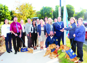 TOWN CELEBRATES WORK OF COPE Caledon councillors gathered outside Town Hall Tuesday morning with some visitors, including some of the canine variety, to raise a flag in recognition of the work done by Canine Opportunity People Empowerment (COPE) Service Dogs. The program aims to unleash potential in people with disabilities by placing them with trained service dogs. Students at Humberview Secondary School in Bolton are also involved with the training of the dogs. On hand for the flag raising was Lynn Acri from COPE, Doug Maskell from Humberview, Councillors Doug Beffort, Gord McClure, Annette Groves, Nick deBoer, Jennifer Innis, Johanna Downey, Barb Shaughnessy and Rob Mezzapelli and Mayor Allan Thompson, along with Edward Galbo, Barb Koetsier and Jackie Tugnett of COPE. Photo by Bill Rea