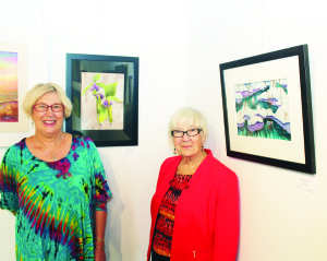 OPENING RECEPTION AT ALTON MILL Saturday saw the opening reception of Seasons by Silk Painters of Ontario. The creations of seven area artists are on display at Alton Mill Arts Centre until Sunday. Nell Crathern of Inglewood is seen here with her creation entitled Jack in the Pulpit, while Dianne Sutter of Brampton stands next to Spring Melt. Photo by Bill Rea