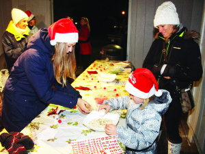 There were crafts to be made at Saturday's festivities. Volunteer Sophie Potter was assisting Gracie Stoppenbrink, 6, of Palgrave make reindeer food, while her mother Sheryl watched.