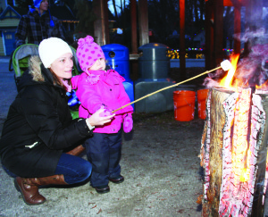 Marshmallows always taste better when they've been toasted over an open fire, and Jodie Kirkpatrick was showing her daughter Mackenzie, 3, how it's done. They were among the local residents taking part in Jinglewood Sunday evening, near the Inglewood Fire Hall.