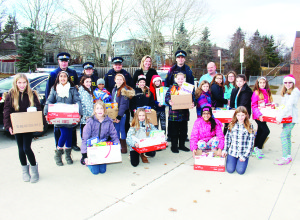 Constables Kevin Johnston and Brenda Evans, Sergeant Marcus Sanders, teacher Jennifer Caruk, Principal Andrew Greenhow and Constable Greg Page helped these students at Ellwood Memorial Public School. Photos by Bill Rea