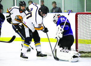 Caledon's Daniel Stretton gets real close with Penetang goaltender Andrew North at Caledon East Sunday. The Golden Hawks trail the Kings 2-1 in the GMOHL best-of-seven semifinal. Photo by Jake Courtepatte
