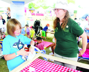 Volunteers at the Eco Caledon tent were showing people how to make matts out of milk bags. Betty de Groot, a teacher at St. John the Baptist Elementary School in Bolton, was giving Kate Delaney, 8, of Belwood some pointers. Photos by Bill Rea