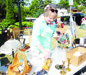 SALE AT ST. JAMES' CHURCH There were lots of interesting items, both inside and on the lawn, recently at the sale that was held at St. James' Anglican Church in Caledon East. Diane Allengame was busy sorting through the inventory.          Photo by Bill Rea