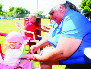 Members of the Caledon Optimist Club were on hand, putting tattoos of some of the young people attending Inglewood Day. Sue Montgomery was fixing a tattoo for Cailey Love, 2, of Mono. Photos by Bill Rea