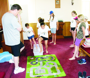Vacation Bible School at Caven There was lots of fun going on recently at Caven Presbyterian Church in Bolton as it was the scene of annual Vacation Bible School activities. The theme of this year's event was Cave Quest. Rev. Jeremy Lowther was using a number of devices to outline some of the stories in the Bible, including this demonstration on how tricky it is to walk on water. There were fun activities too, as Kiley Osadca, 8, and Gianna Williams, 7, were making cave slime, as part of the Cave Quest theme.       Photos by Bill Rea