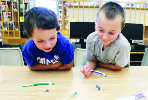 FUN AT BRISTLEBOT Nolan Kring, 7, of Bolton and Will Harasiewicz, 9, of Caledon East were having fun last Thursday with the bristlebots they created at the program run at the Caledon East branch of Caledon Public Library. The bristlebots are tiny robots, made with the little motors and batteries attached to the bristles of toothbrushes. Photo by Bill Rea