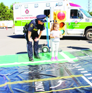 Caledon OPP were on hand Saturday at Bolton Fall Fair to help teach young people some of the safety rules in traffic. Constable Stephanie Hammond was making sure Camila Dos Santos, 5, of Orangeville knew to look both ways before crossing the street. Photos by Bill Rea
