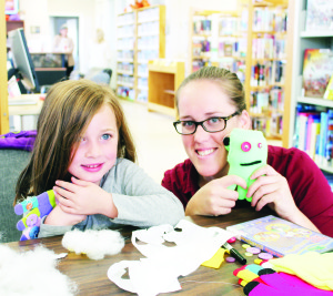GLOVE MONSTERS AT LIBRARY It was a time to let imagination run wild at the caledon village branch of Caledon Public Library Saturday as young folks got the chance to make cleaver creatures out of gloves. Samantha Dillane was offering some tips to Lea Zahra, 5. Photo by Bill Rea