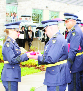 Chief Superintendent Rose Di Marco, of the OPP Central Region, took the flag that was flying outside the Caledon OPP station last Thursday and presented it to the retiring Inspector Tim Melanson, as his successor, Inspector Ryan Carothers, looked on.