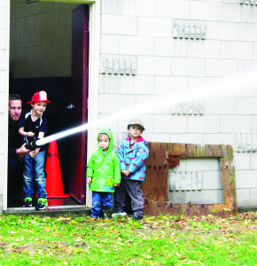There were fun things to try at the open house at the Palgrave Fire Hall. Firefighter Eric Gravenish was helping Thomas Spencer, 6, aim this hose at a target while his brothers George, 2, and Henry, 4, looked on. Photos by Bill Rea